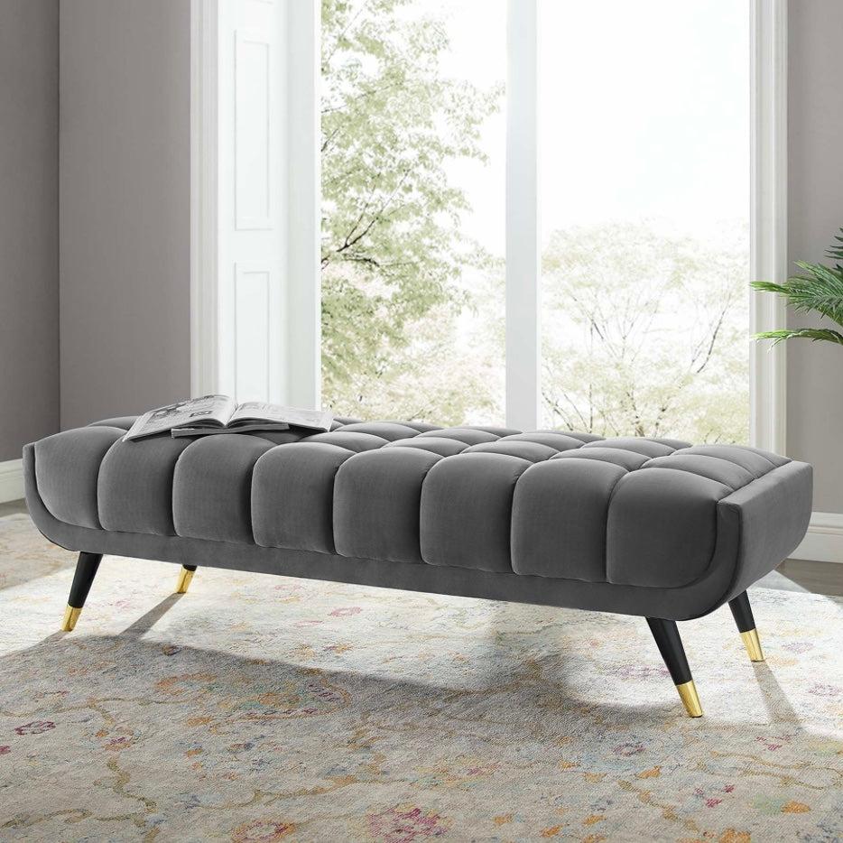 Grey upholstered channel bench with black and gold legs
